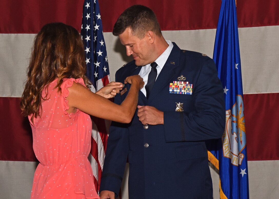 U.S. Air Force Lt. Col. Michael McCourt, incoming 312th Training Squadron commander, receives his commander’s pin from his wife during the change of command ceremony at the Louis F. Garland Department of Defense Fire Academy High Bay on Goodfellow Air Force Base, Texas, June 19, 2019. The pin signifies that McCourt holds the position of commander of the squadron. (U.S. Air Force photo by Airman 1st Class Zachary Chapman/Released)