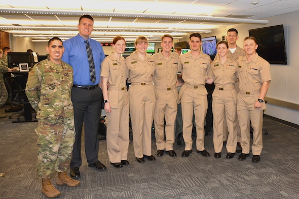 United States Naval Academy Midshipmen pose for a group photo with staff from the 15th Operational Weather Squadron at Scott Air Force Base, Illinois, May 11, 2019. Midshipmen visit the 15th OWS annually to learn about convective storms, which can cause hazardous weather such as tornadoes, hail, lightning and heavy rain. (U.S. Air Force photo by Airman 1st Class Austin Durila)
