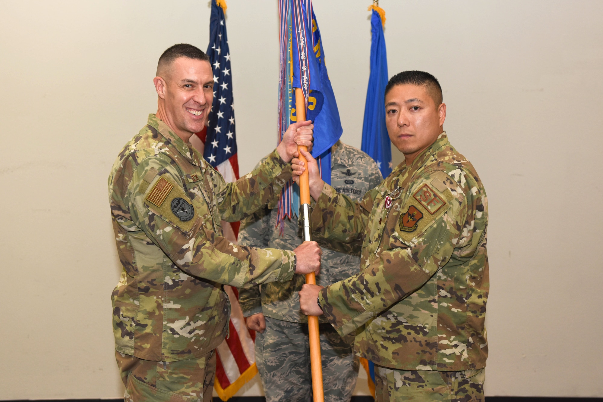 U.S. Air Force Col. Jason Beck, 17th Mission Support Group commander, accepts the guideon from Maj. Min Lee, 17th Security Forces outgoing commander, during the 17th SFS Change of Command at the event center on Goodfellow Air Force Base, Texas, June 19, 2019. The passing of the guideon represents the formal exchange of command. (U.S. Air Force photo by Senior Airman Seraiah Hines/Released)