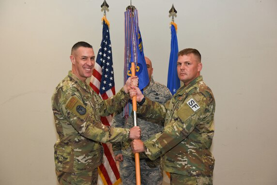 U.S. Air Force Col. Jason Beck, 17th Mission Support Group commander, presents Maj. Richard Buckley, incoming 17th Security Forces Squadron commander, with the guideon during the change of command ceremony at the event center on Goodfellow Air Force Base, Texas, June 19, 2019. Buckley commissioned through the Reserve Officer Training Corps as a distinguished graduate in 2005. (U.S. Air Force photo by Senior Airman Seraiah Hines/Released)