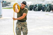 U.S. Marine Corps Pfc. Brandon Zamora rolls an extension cord at Camp Kinser, Okinawa, Japan, June 13, 2019.  Zamora, a heavy equipment mechanic with Motor Transport Platoon, Headquarters Company, Combat Logistics Regiment 37, 3rd Marine Logistics Group, is a native of Sacramento, California. (U.S. Marine Corps photo by Cpl. Joshua Pinkney)
