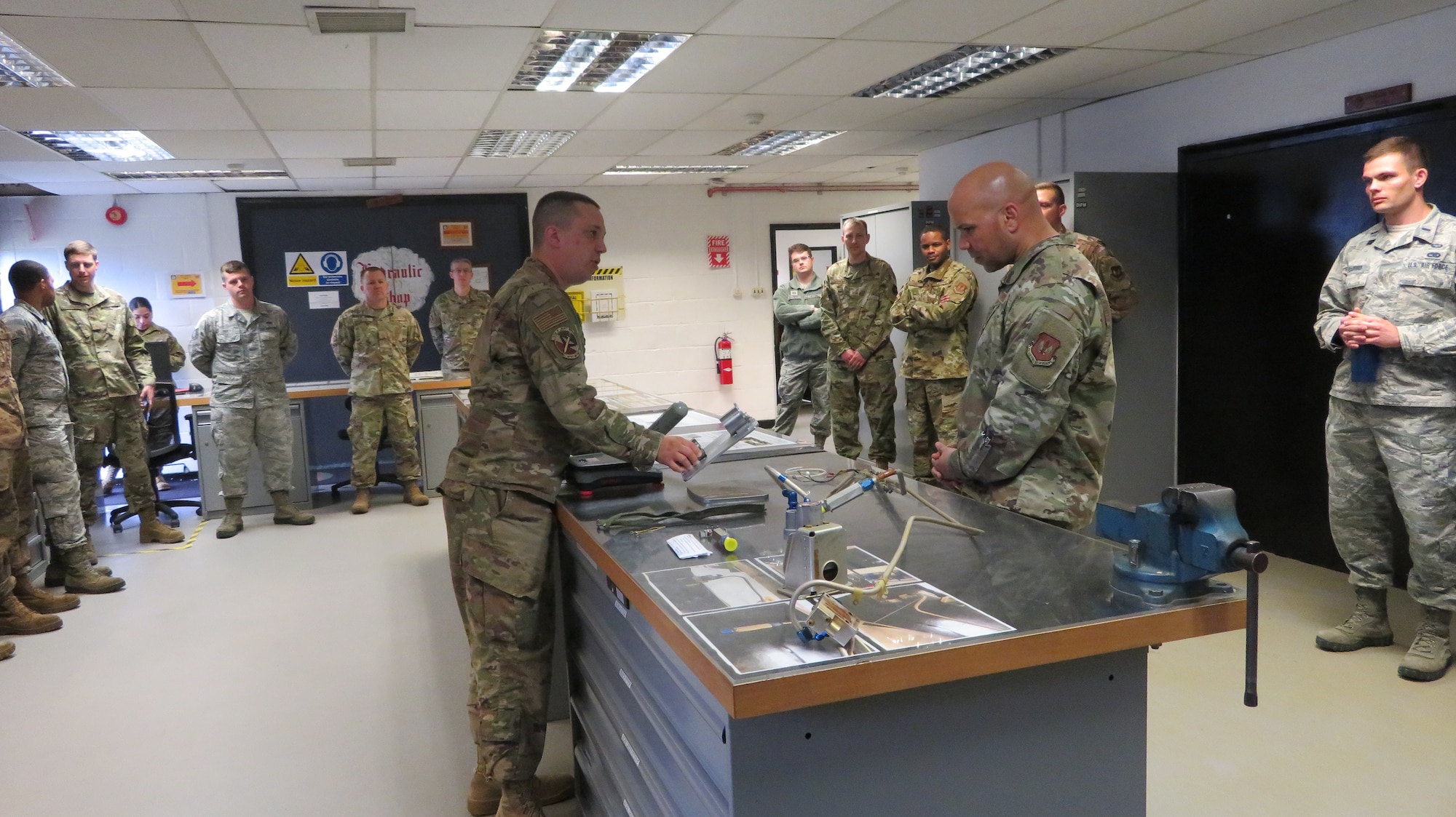 Tech. Sgt. Aaron Suter, 48th Component Maintenance Squadron Electrical and Environmental shop noncommissioned officer in-charge, presents the recent innovations from his shop to Chief Master Sgt Daniel Guzman, U.S. Air Forces in Europe first sergeant, at Royal Air Force Lakenheath, England, May 17, 2019. The E&E shop developed field level procedures to restore throttle grips on F-15 Eagles, saving the 48th Fighter Wing 110 maintenance man hours and more than $26,000. (Courtesy photo)