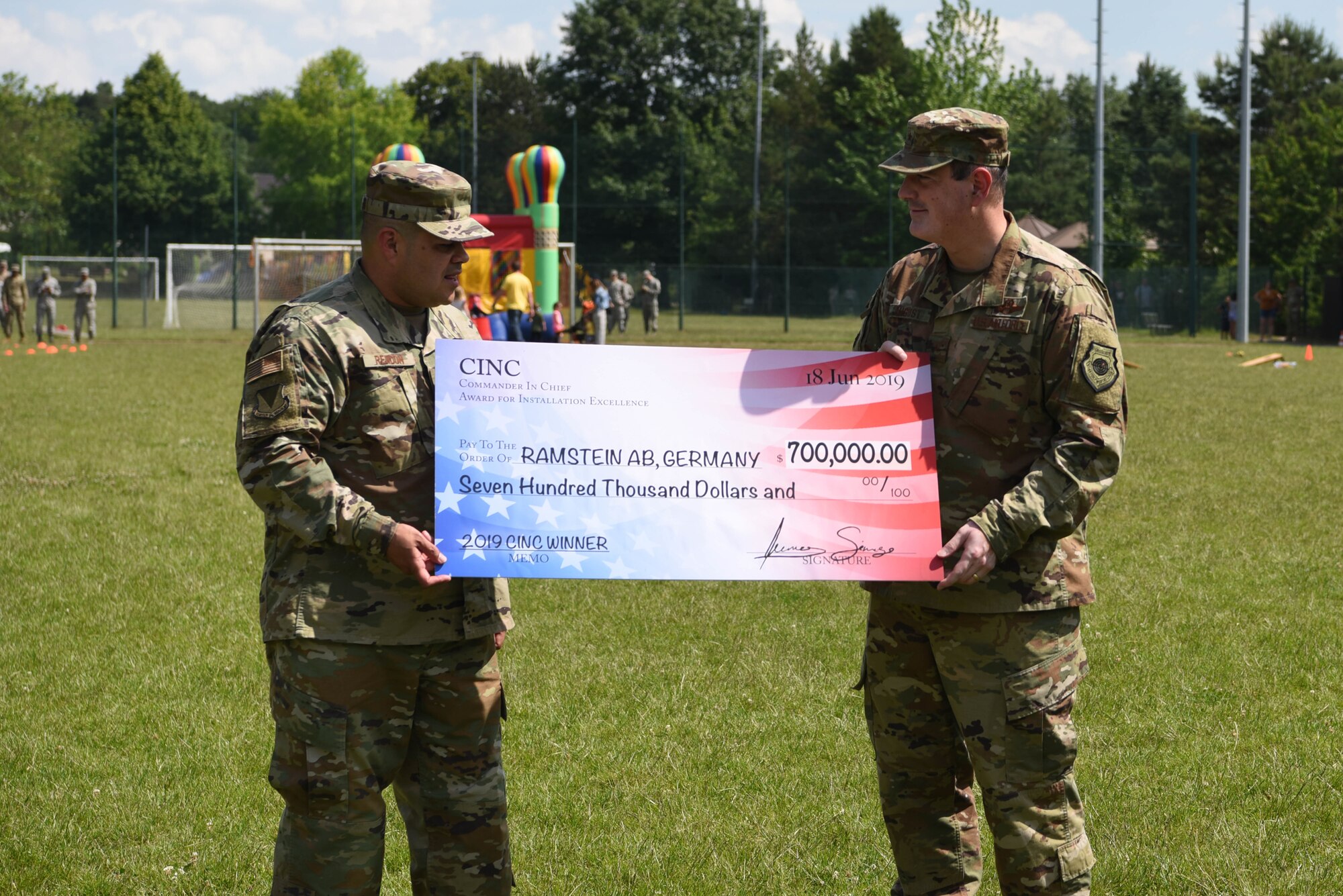 U.S. Air Force Brig. Gen. Mark August, 86th Airlift Wing commander and U.S. Air Force Chief Master Sgt. Ernesto Rendon, 86th AW command chief, pose for a picture with a prize money check from the Installation Excellence Award, at Donnelly Park on Ramstein Air Base, Germany, June, 18, 2019. The $700,000 prize money is scheduled to be used to further quality of life and installation management initiatives.