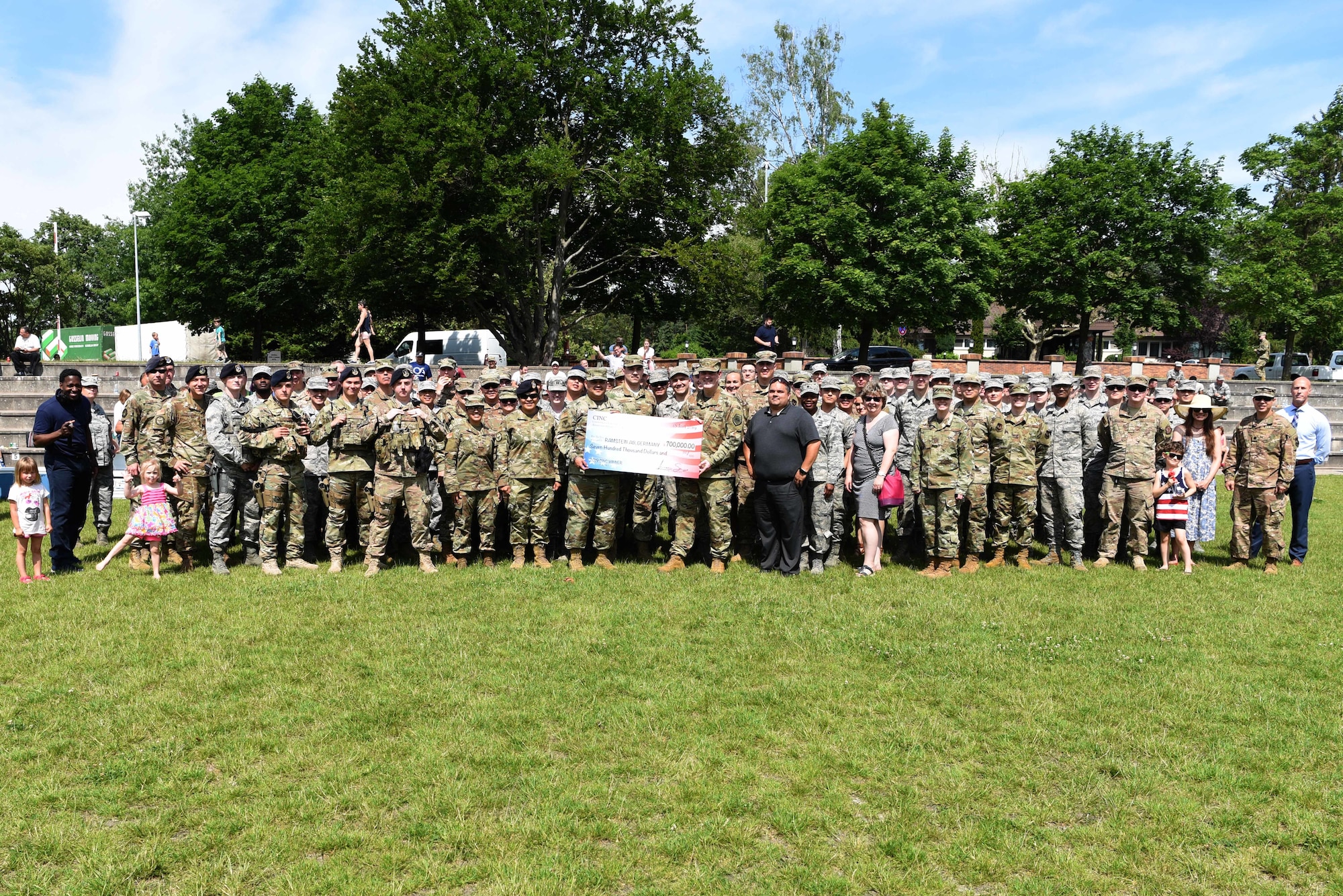 U.S. Air Force Brig. Gen. Mark August, 86th Airlift Wing commander and U.S. Air Force Chief Master Sgt. Ernesto Rendon, 86th AW command chief, pose for a picture with a group of Aimen during the Commander in Chief’s Installation Excellence Award barbecue at Donnelly Park, on Ramstein Air Base, Germany, June, 18, 2019. The barbecue was held to honor all Ramstein Airmen who played a part in allowing Ramstein to win the CINC Excellence Award.