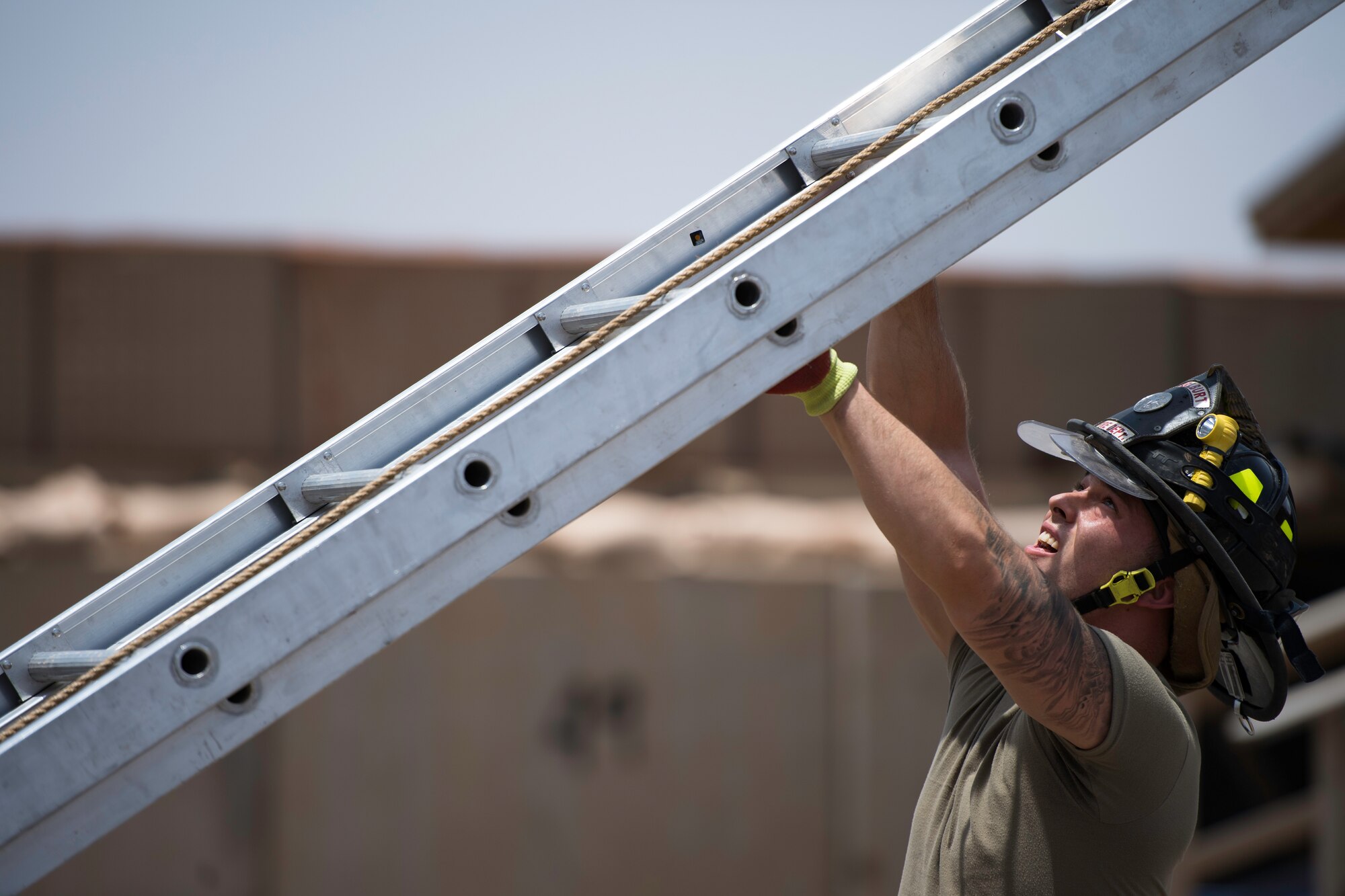 U.S. Air Force Senior Airman Logan Reed, 870th Air Expeditionary Squadron firefighter, throws a ladder at Chabelley Airfield, Djibouti, June 11, 2019. Firefighters must maintain top physical shape in order to perform their daily labor-intensive duties. (U.S. Air Force photo by Staff Sgt. Devin Boyer)