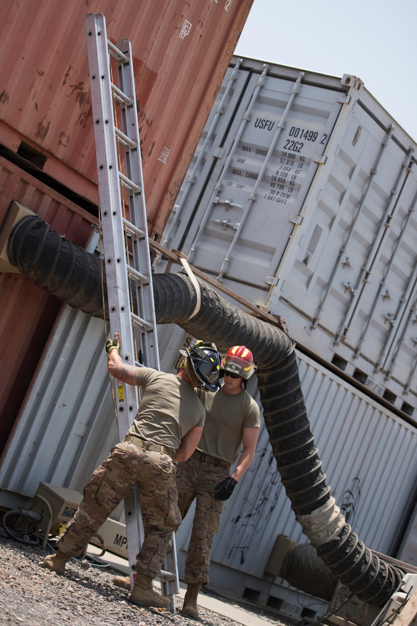 U.S. Air Force Senior Airman Logan Reed and Staff Sgt. Branden Sherwood, 870th Air Expeditionary Squadron firefighters, set up a ladder at Chabelley Airfield, Djibouti, June 11, 2019. Throwing ladders is a common practice for firefighters maintaining readiness. (U.S. Air Force photo by Staff Sgt. Devin Boyer)