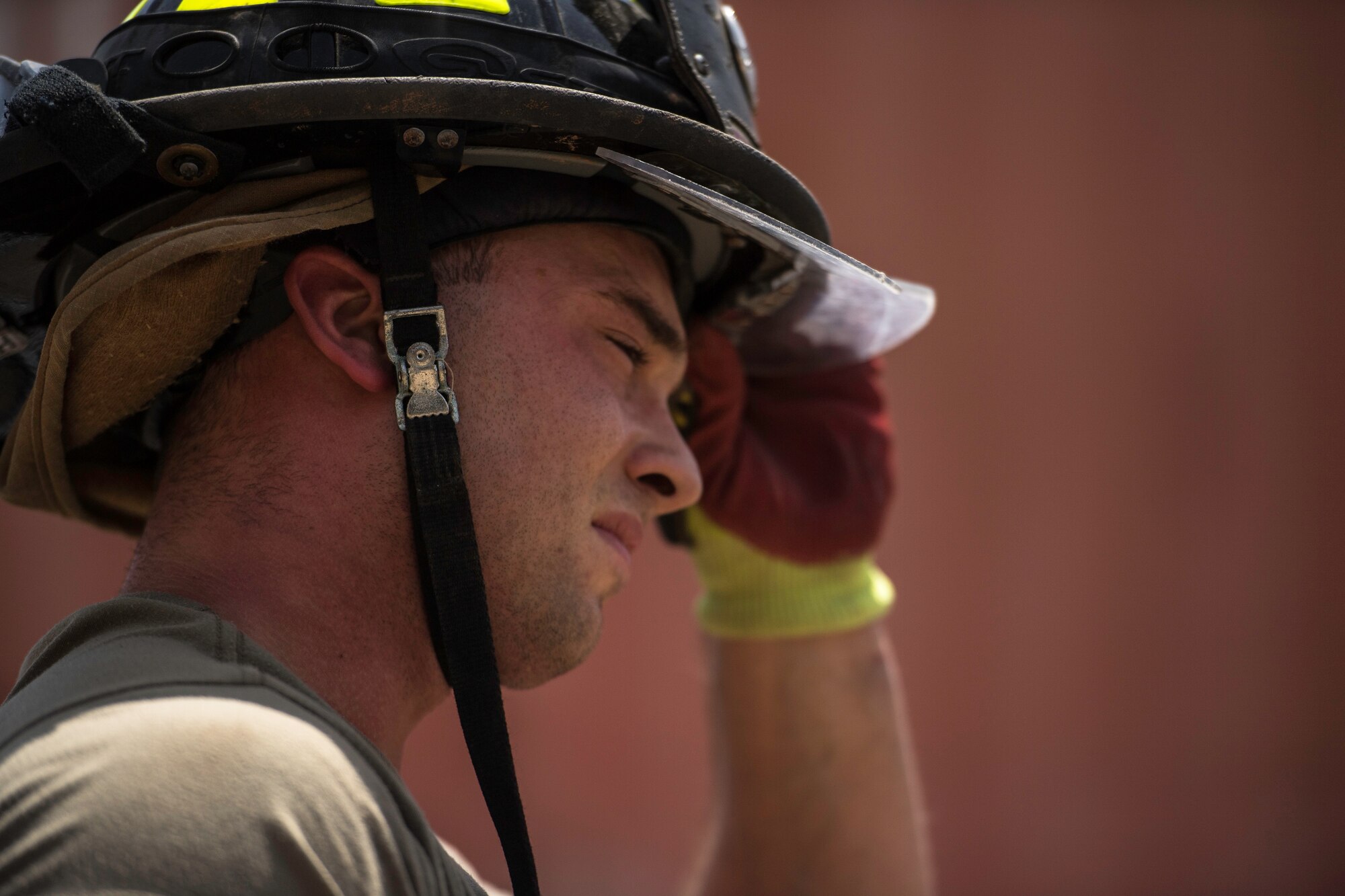 U.S. Air Force Senior Airman Logan Reed, 870th Air Expeditionary Squadron firefighter, adjusts his helmet at Chabelley Airfield, Djibouti, June 11, 2019. The 870th AES firefighters support the mission in East Africa by providing emergency services to the 449th Air Expeditionary Group and their assets. (U.S. Air Force photo by Staff Sgt. Devin Boyer)