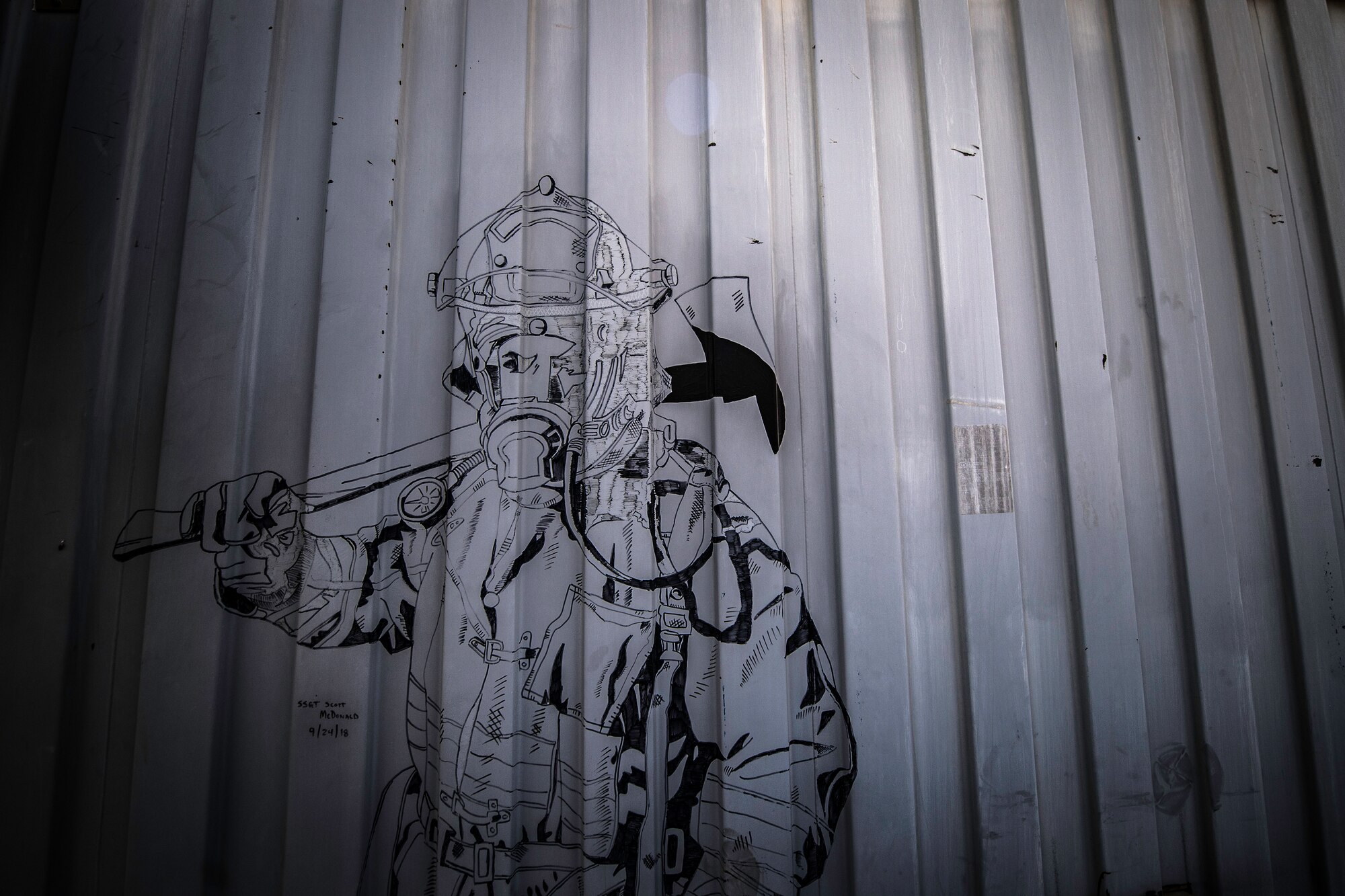 A drawing of a firefighter is displayed on a metal trailer at the 870th Air Expeditionary Squadron fire department at Chabelley Airfield, Djibouti, June 11, 2019. The fire department is responsible for responding to fires and incidents on the flight line. (U.S. Air Force photo by Staff Sgt. Devin Boyer)