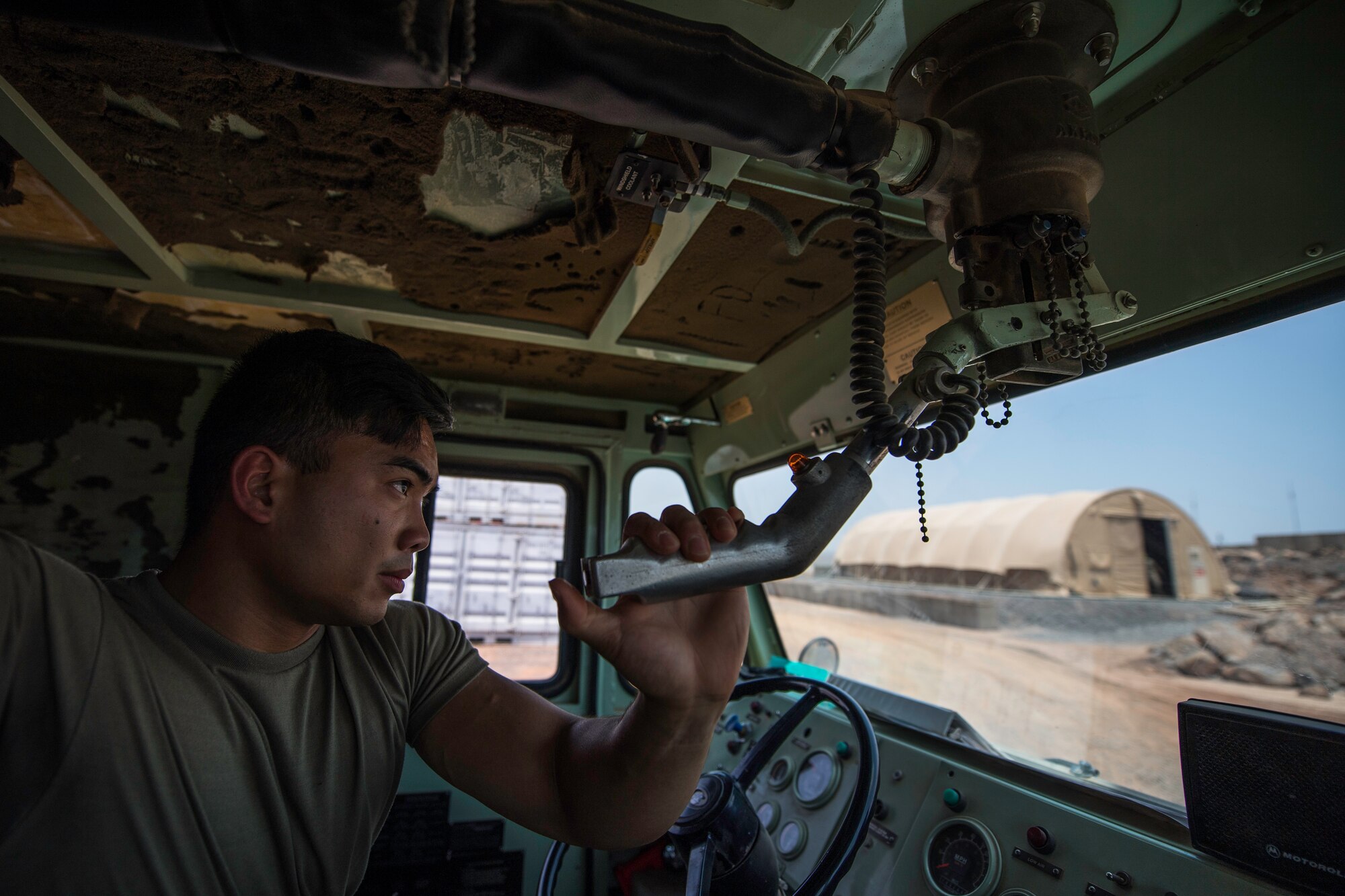 U.S. Air Force Airman 1st Class Anthon Williams, 870th Air Expeditionary Squadron firefighter, pulls a lever to trigger the fire truck’s front hose at Chabelley Airfield, Djibouti, June 11, 2019. Williams and his fellow Airmen inspect the equipment daily to ensure the team’s readiness. (U.S. Air Force photo by Staff Sgt. Devin Boyer)