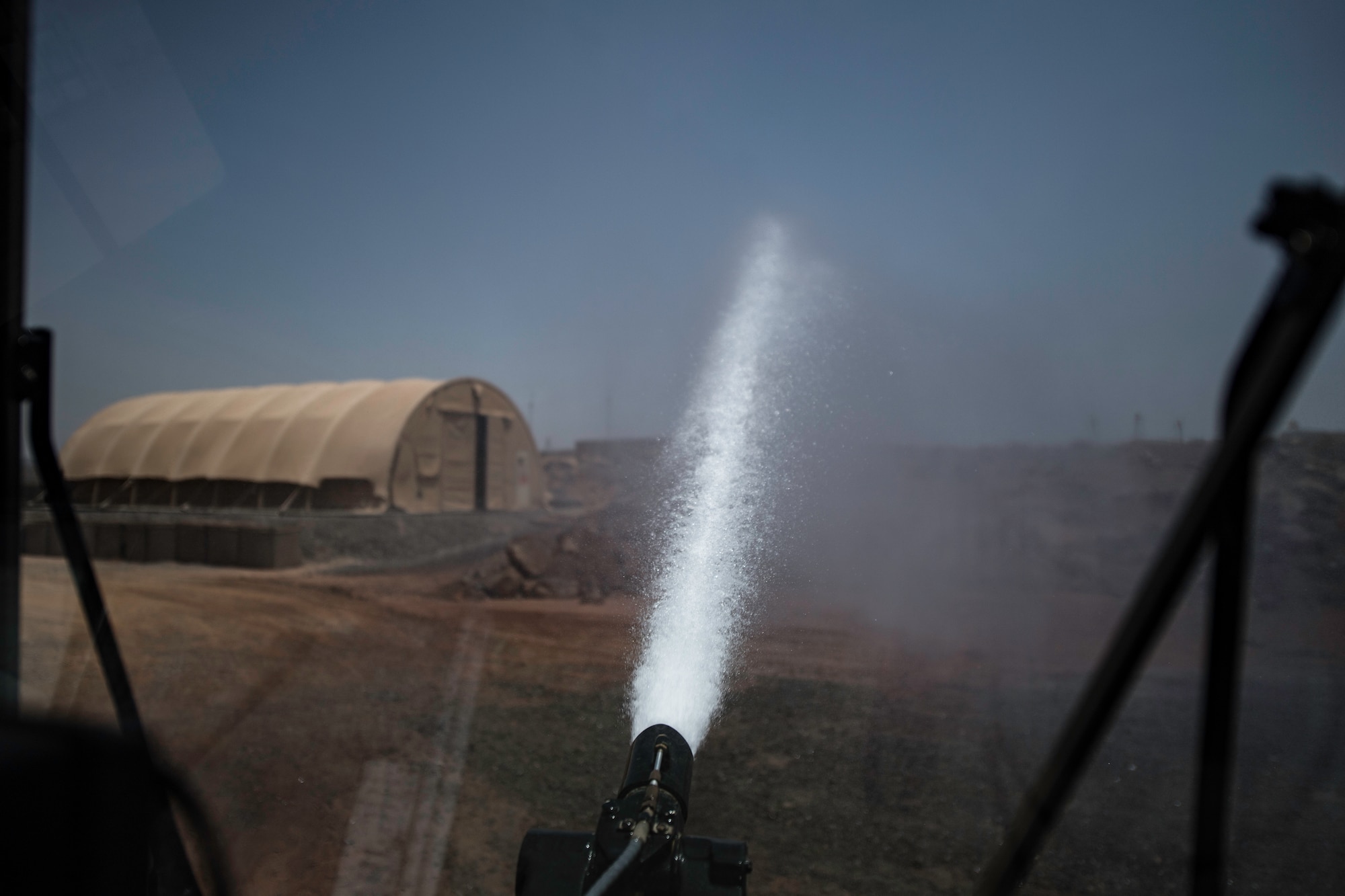 A fire truck assigned to the 870th Air Expeditionary Squadron fire department sprays water out of a hose at the 870th AES fire department at Chabelley Airfield, Djibouti, June 11, 2019. The fire department must ensure all equipment is functional in case there is an emergency. (U.S. Air Force photo by Staff Sgt. Devin Boyer)