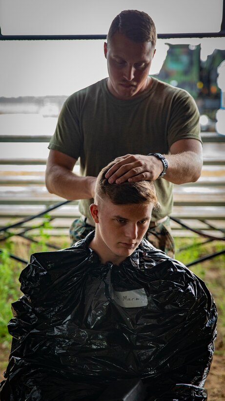 U.S. Marine Corps Pfc. John Radtke, bottom, receives a haircut from Cpl. Daniel Heinrich, top, both motor vehicle operators with Marine Wing Support Squadron 471, Marine Aircraft Group 41, 4th Marine Aircraft Wing, at Canadian Forces Base Cold Lake, Canada, June 19, 2019, in support of Sentinel Edge 19. Training exercises, such as SE19, ensure Reserve Marines are proficient and capable of successful integration with active-duty Marines, making MARFORRES critical to the Marine Corps’ Total Force. (U.S. Marine Corps photo by Lance Cpl. Jose Gonzalez)