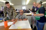 Oregon Air National Guard Capt. Kevin Lindsey , left, along with Capt. Vincent Faustino and State Emergency Registry of Volunteers in Oregon (SERV-OR) discuss strike and recovery teams during Pathfinder Exercise 2019, June 13, 2019, at Camp Rilea, Warrenton, Oregon.