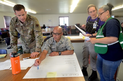 Oregon Air National Guard Capt. Kevin Lindsey , left, along with Capt. Vincent Faustino and State Emergency Registry of Volunteers in Oregon (SERV-OR) discuss strike and recovery teams during Pathfinder Exercise 2019, June 13, 2019, at Camp Rilea, Warrenton, Oregon.