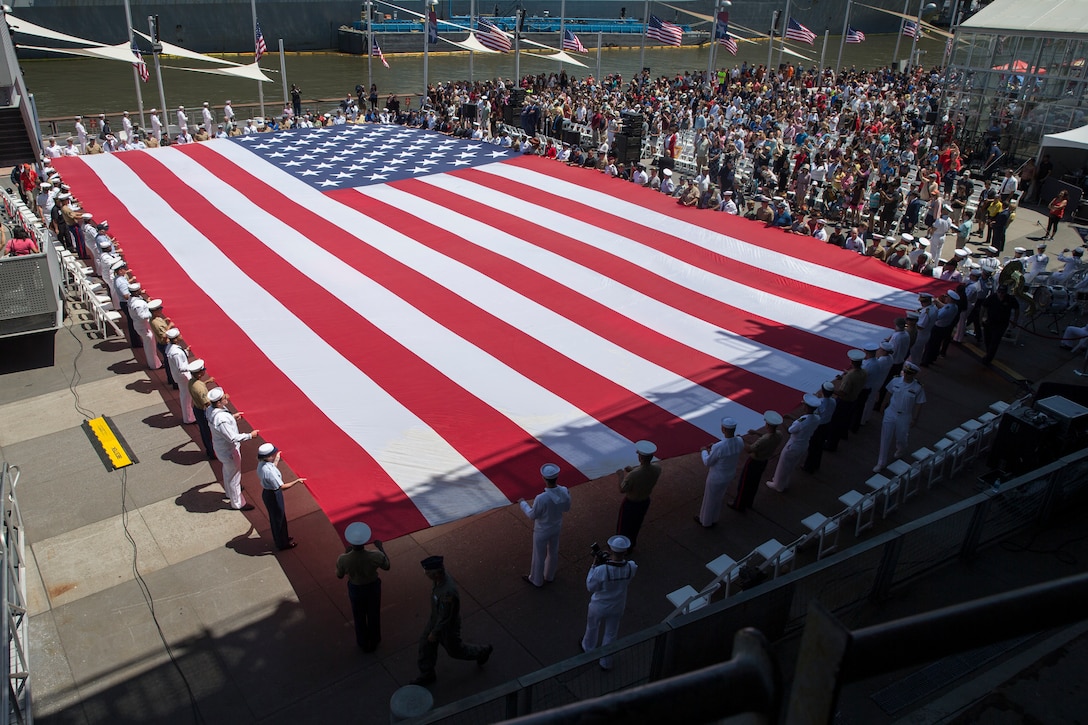 U.S. service members unfurl the United States flag during a Memorial Day ceremony at the Intrepid Sea, Air, and Space Museum as part of Fleet Week New York in New York City NY, May 27, 2019. Memorial Day honors the fallen men and women of the U.S. Armed Forces. Fleet Week NY is an opportunity for the American public to meet their Marine Corps, Navy, and Coast Guard service members and experience America’s sea services firsthand.