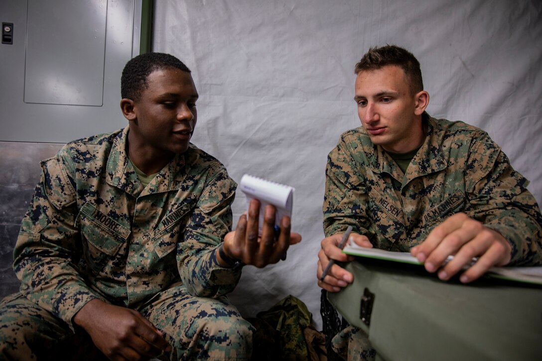 U.S. Marine Corps Lance Cpl. Taivin Moore, left, a scribe, shows his notes to Lance Cpl. Christopher Nelsen, right, a radio watch operator, both with Marine Wing Support Squadron 471, Marine Aircraft Group 41, 4th Marine Aircraft Wing, at Canadian Forces Base Cold Lake, Canada, June 19, 2019, in support of Sentinel Edge 19. Training exercises, such as SE19, ensure Reserve Marines are proficient and capable of successful integration with active-duty Marines, making MARFORRES critical to the Marine Corps’ Total Force. (U.S. Marine Corps photo by Lance Cpl. Jose Gonzalez)