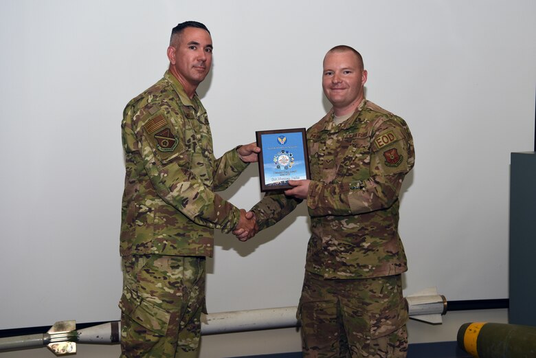 Senior Airman Norman Parks, 377th Civil Engineer Squadron explosive ordnance disposal technician, receives the May Diamond Sharp award from Master Sgt. Jason Meuse, 377th Mission Support Group first sergeant, at Kirtland Air Force Base, N.M., June 19, 2019. Parks used existing spare parts to create a new attachments for the EOD robots, and the new attachment has been implemented throughout the Air Force. Parks was also awarded Senior Airman Below the Zone. (U.S. Air Force photo by Senior Airman Eli Chevalier)