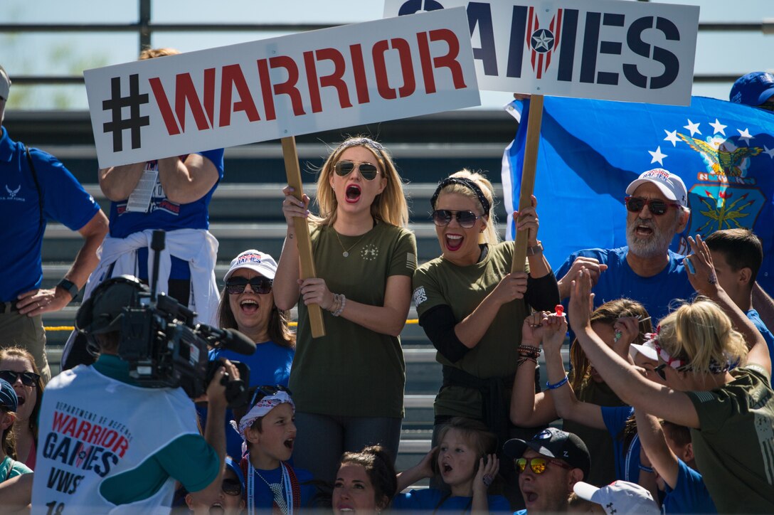 Fans cheer for their favorite athletes during a 2018 DoD Warrior Games Track Competition at the U.S. Air Force Academy in Colorado Springs, Colorado, June 2, 2018. The Warrior Games is an adaptive sports competition for wounded, ill and injured service members and veterans. Approximately 300 athletes representing teams from the Marine Corps, Navy, Army, Air Force, Special Operations Command, United Kingdom Armed Forces, Canadian Armed Forces, and the Australian Defence Force will compete June 1 - June 9 in archery, cycling, track, field, shooting, sitting volleyball, swimming, wheelchair basketball, and - new this year - powerlifting and indoor rowing.
