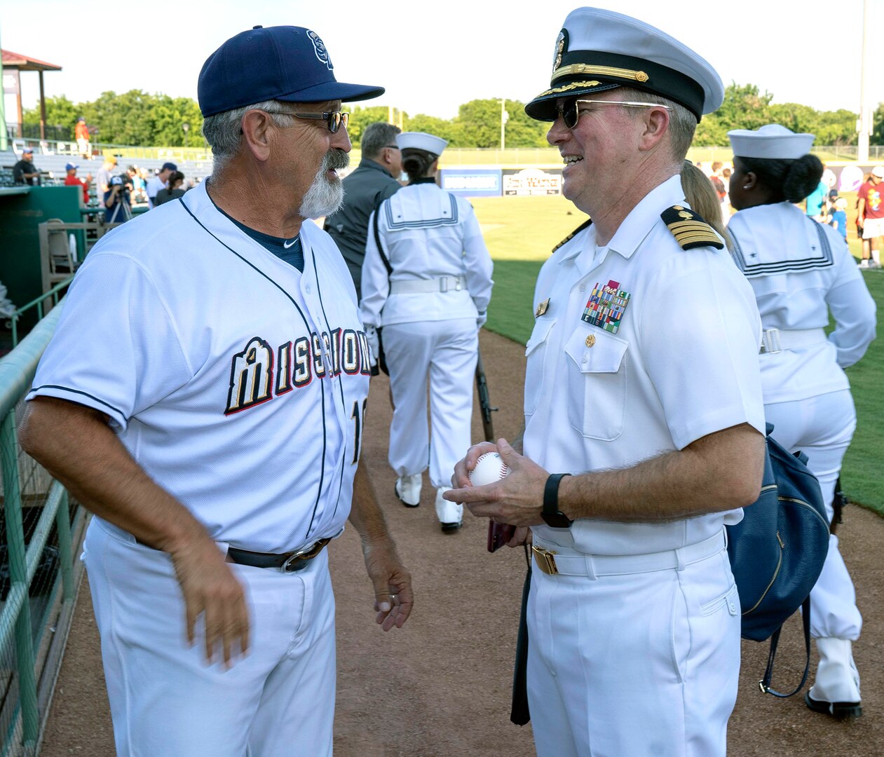 Capt. Timothy Richardson (right), deputy commander of Navy Medicine Education, Training and Logistics Command, or NMETLC, talks with Rick Sweet, manager of the San Antonio Missions baseball team, after throwing out the first pitch at the Missions baseball game in honor of military appreciation night June 12.