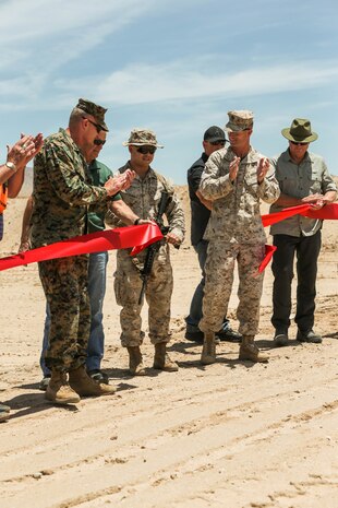 U.S. Marine Corps Sgt. Jacob R. Mott, rifleman, 3rd Battalion, 4th Marine Regiment, 1st Marine Division, cuts the ribbon to celebrate the re-opening of Range 105A, Marine Corps Air Ground Combat Center, Twentynine Palms, Calif., Jun 17, 2019. The range was re-designed to offer multiple, efficient types of training to individual Marines and squad-sized elements. (U.S. Marine Corps photo by Pfc. Gustavo Romero)