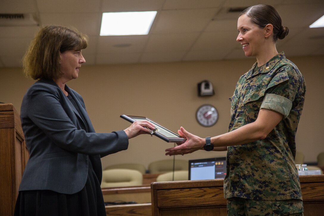 Marci Jensen-Eldred (left), chief attorney, San Bernardino County Child Support Services, presents a certificate of appreciation to Maj. Kerry E. Friedewald, legal assistant officer in charge, Legal Service Support Team, Headquarters Battalion, Marine Corps Air Ground Combat Center (MCAGCC) at MCAGCC, Twentynine Palms, Calif., June 18, 2019. The section was awarded a certificate of appreciation for their work with the San Bernardino County Child Support Services.  (U.S. Marine Corps photo by Cpl. Francisco J. Britoramirez)