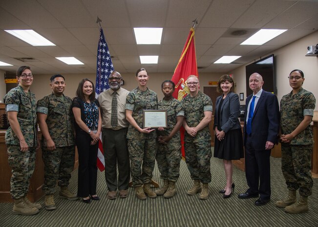 Marines with Legal Services Support Team, Headquarters Battalion, Marine Corps Air Ground Combat Center (MCAGCC), display a certificate of appreciation given by members of the San Bernardino County Child Support Services at MCAGCC, Twentynine Palms, Calif., June 18, 2019. The section was awarded a certificate of appreciation for their work with the San Bernardino County Child Support Services.  (U.S. Marine Corps photo by Cpl. Francisco J. Britoramirez)