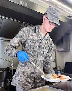 Airman Brion Flores, a member of the 149th Force Support Squadron, cooks a meal in a containerized kitchen during Home Station Readiness Training in California at March Air Reserve Base ‪June 17-2‬2. Containerize kitchen units can be set up quickly and efficiently in remote locations, disaster areas or field training sites.