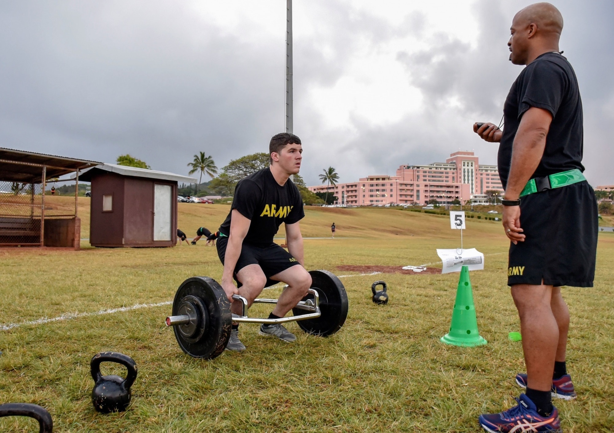 Sgt. 1st Class Jarrod Vining (right), noncommissioned officer in charge, Department of Physical Medicine & Rehabilitation, Tripler Army Medical Center, coaches Sgt. Dominic Falzarano, left, cash control NCOIC, TAMC Nutrition Care Department, during a Spartan Army Combat Physical Training course at the TAMC track in Honolulu April 17.
