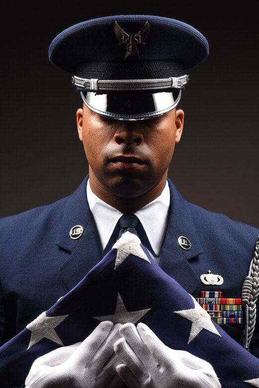 Honor Guard program manager grips a folded flag