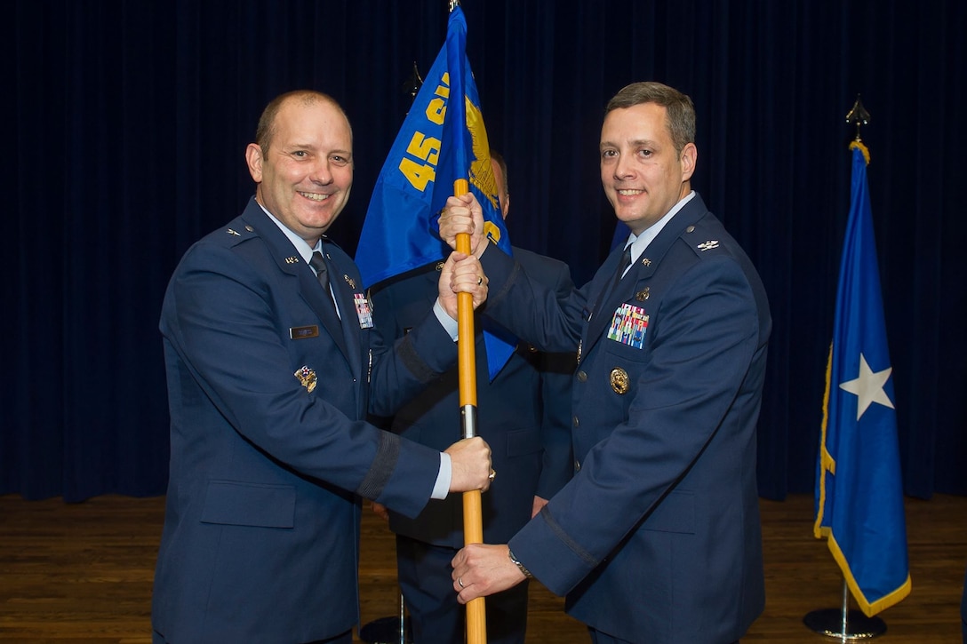 Brig. Gen. Douglas Shiess, 45th Space Wing commander, presents Col. Edward Marshall, incoming 45th Mission Support Group commander, with the 45th MSG guidon as he assumes command of the squadron. (U.S. Air Force photo by Jared Trimarchi)