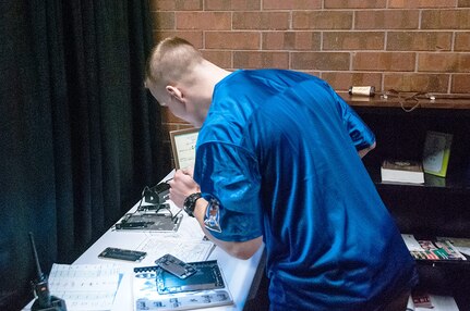 SPC Michael Renner of the 341st Military Intelligence Battalion, Washington Army National Guard, uses personal items of a fictional adversary to create a mock profile during the Site Exploration event of the 2019 Polyglot Games at the brigade’s 30th Annual Language Conference, March 2019.