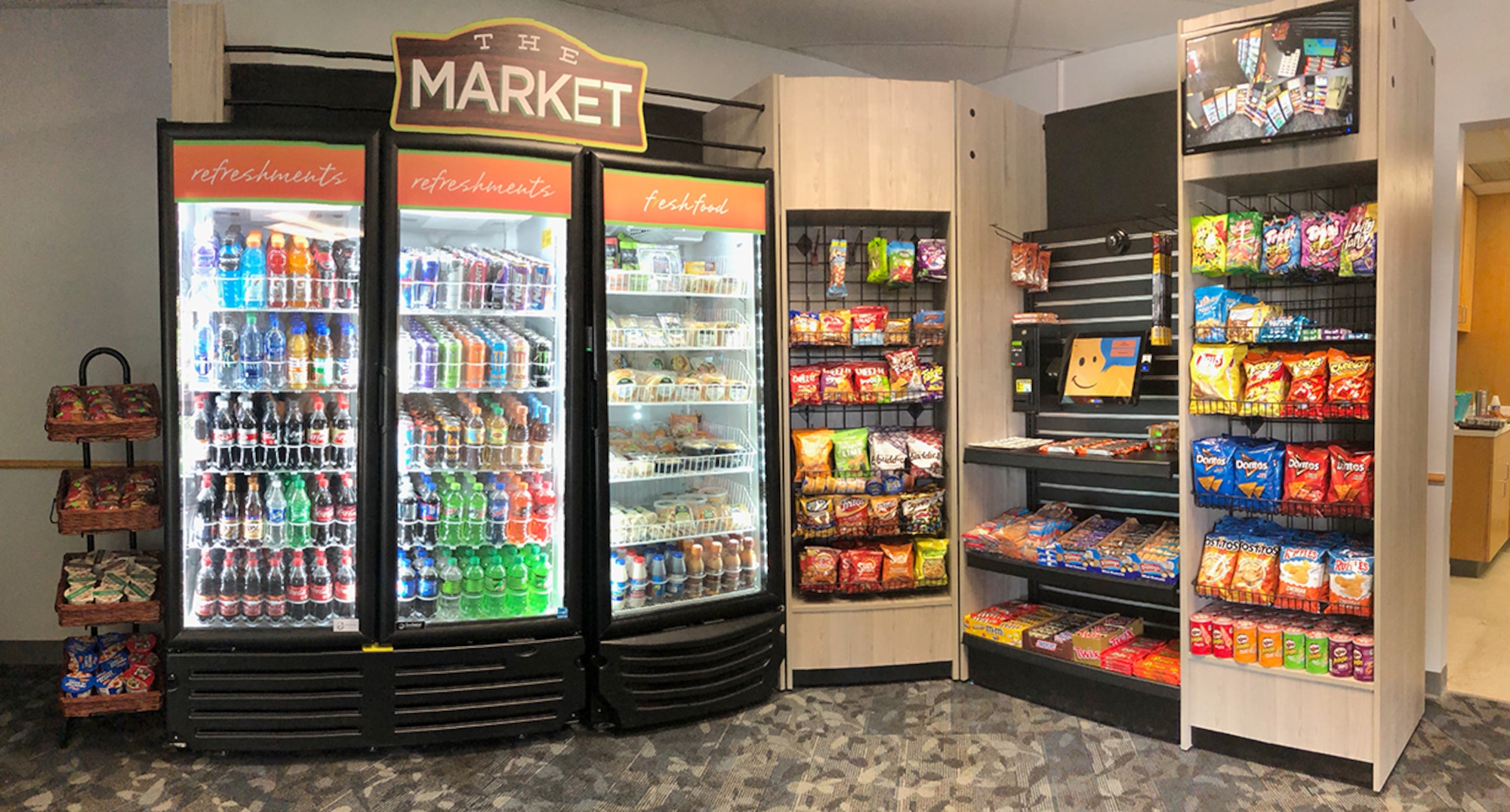 The first Micro Markets opened this week in Bldgs. 5929 and 5947. Micro Markets are mini-marts housed in the bottom of dormitories that are accessible 24/7. Consumers are able to make purchases with cash, card or credit through a key fob loyalty program. Partnering with the Army & Air Force Exchange Service and Imperial Vending, the Micro Markets are in place to compensate for the Dining Facility’s renovation closure. 72nd Air Base Wing Command Chief Master Sergeant Melissa Erb cuts the ribbon on the grand opening of the Bldg. 5929 Micro Market June 18 with Tinker Exchange Services Manager Angela Gray, Imperial Vending Distributor Jeremy Willhite and Exchange General Manager Vanessa Roland.