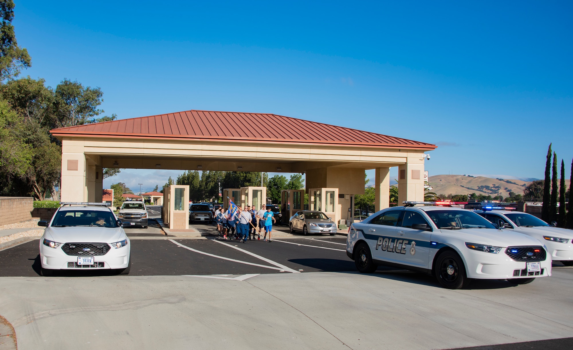 U.S. Air Force patrol vehicles escort 60th Security Forces Squadron defenders and athletes from Solano County through the main gate during the Northern California Law Enforcement Torch Run June 20, 2019, at Travis Air Force Base, California Hundreds of Law Enforcement personnel from northern California escorted the Special Olympics torch, the Flame of Hope, throughout their local communities in a relay to the 2019 Special Olympics Northern California Summer Games, being held at the University of California Davis campus June 21-23. (U.S. Air Force photo by Heide Couch)