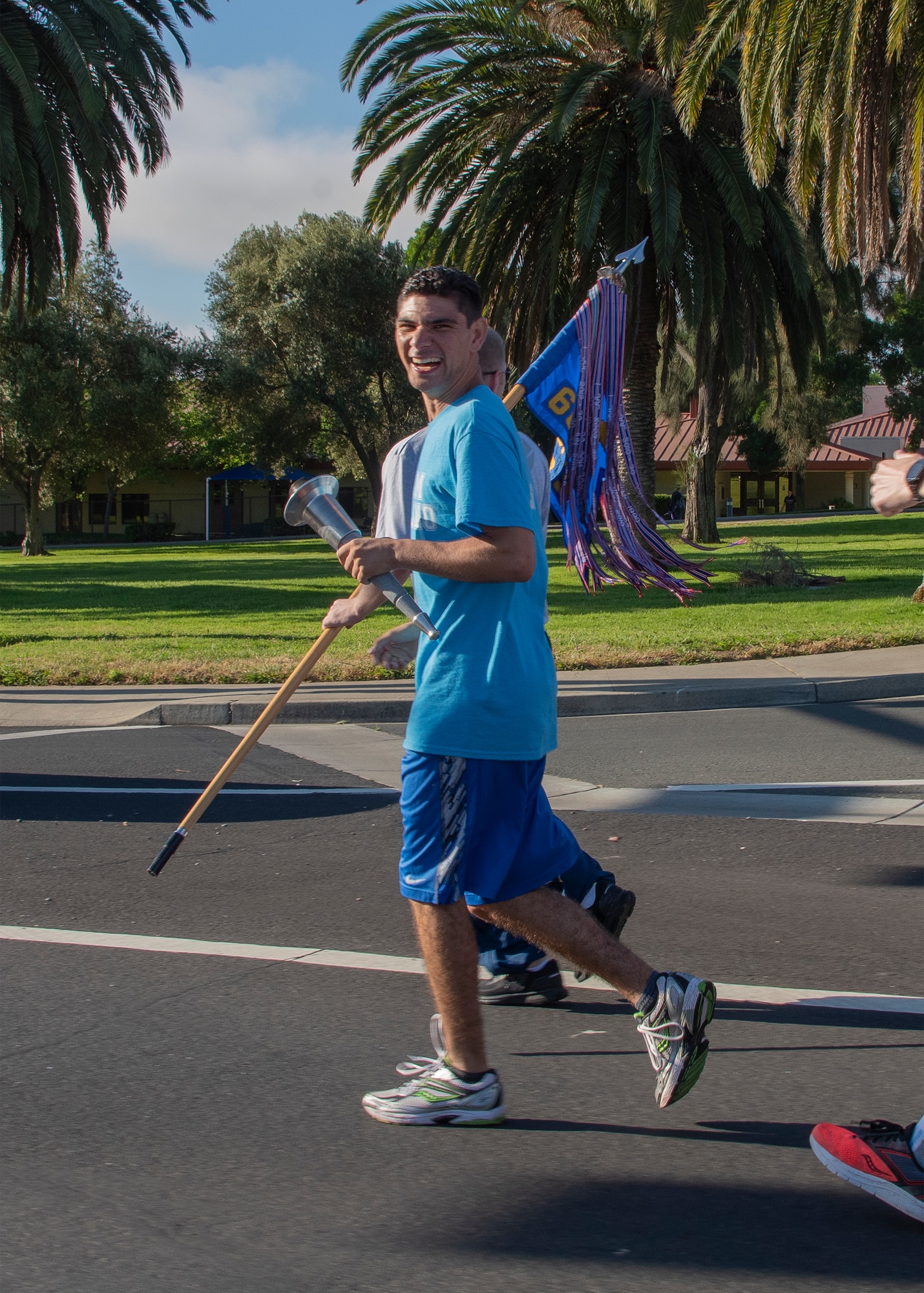 Erik Silva, a Special Olympics runner, holds a torch as he runs with U.S. Air Force 60th Security Forces Squadron defenders and athletes from Solano County during the Northern California Law Enforcement Torch Run June 20, 2019, at Travis Air Force Base, California. Hundreds of Law Enforcement personnel from northern California escorted the Special Olympics torch, the Flame of Hope, throughout their local communities in a relay to the 2019 Special Olympics Northern California Summer Games, being held at the University of California Davis campus June 21-23. (U.S. Air Force photo by Heide Couch)