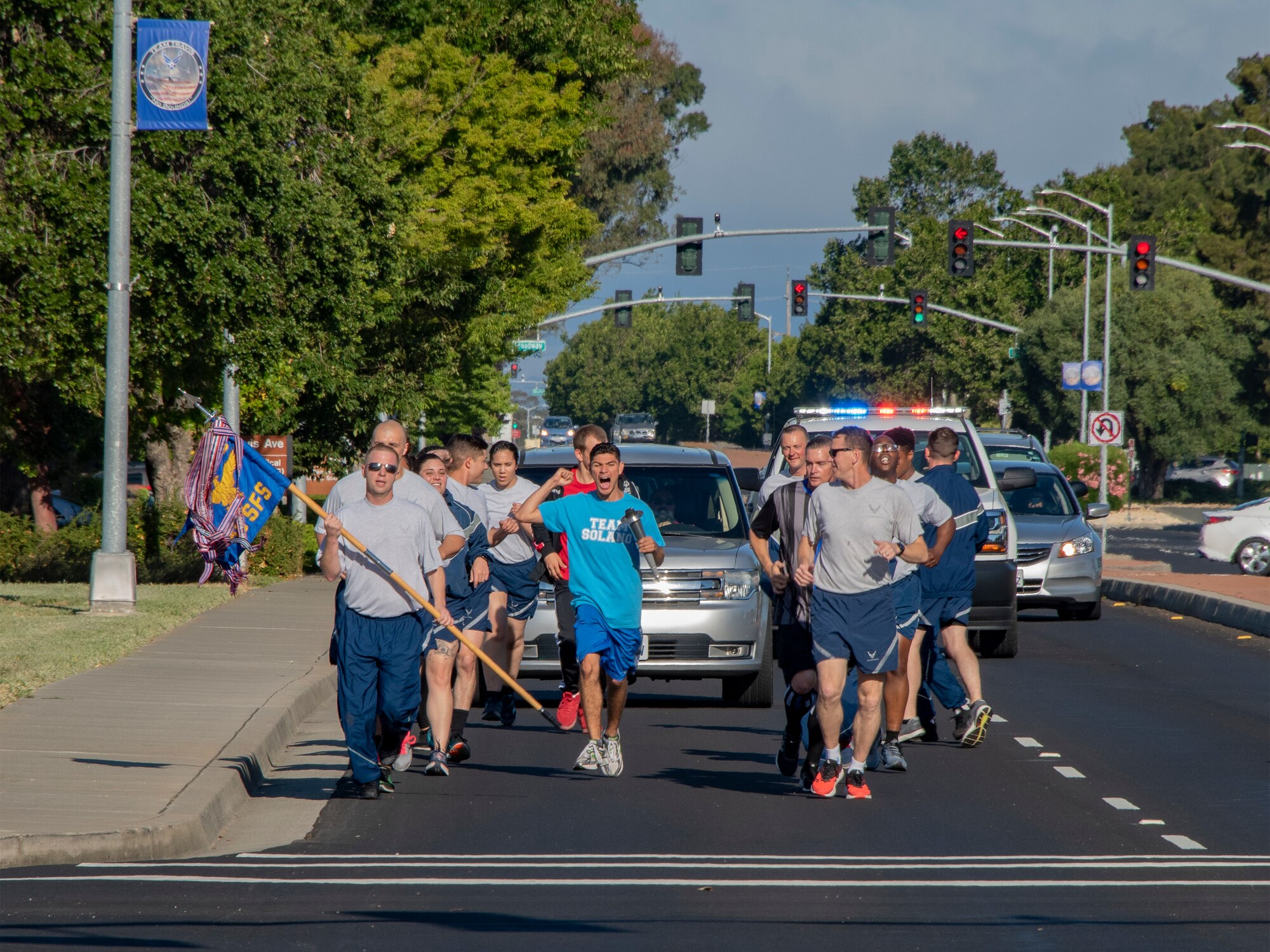 U.S. Air Force 60th Security Forces Squadron defenders and athletes from Solano County make their way eastward on Travis Avenue during the Northern California Law Enforcement Torch Run June 20, 2019, at Travis Air Force Base, California. Hundreds of Law Enforcement personnel from northern California escorted the Special Olympics torch, the Flame of Hope, throughout their local communities in a relay to the 2019 Special Olympics Northern California Summer Games, being held at the University of California Davis campus June 21-23. (U.S. Air Force photo by Heide Couch)