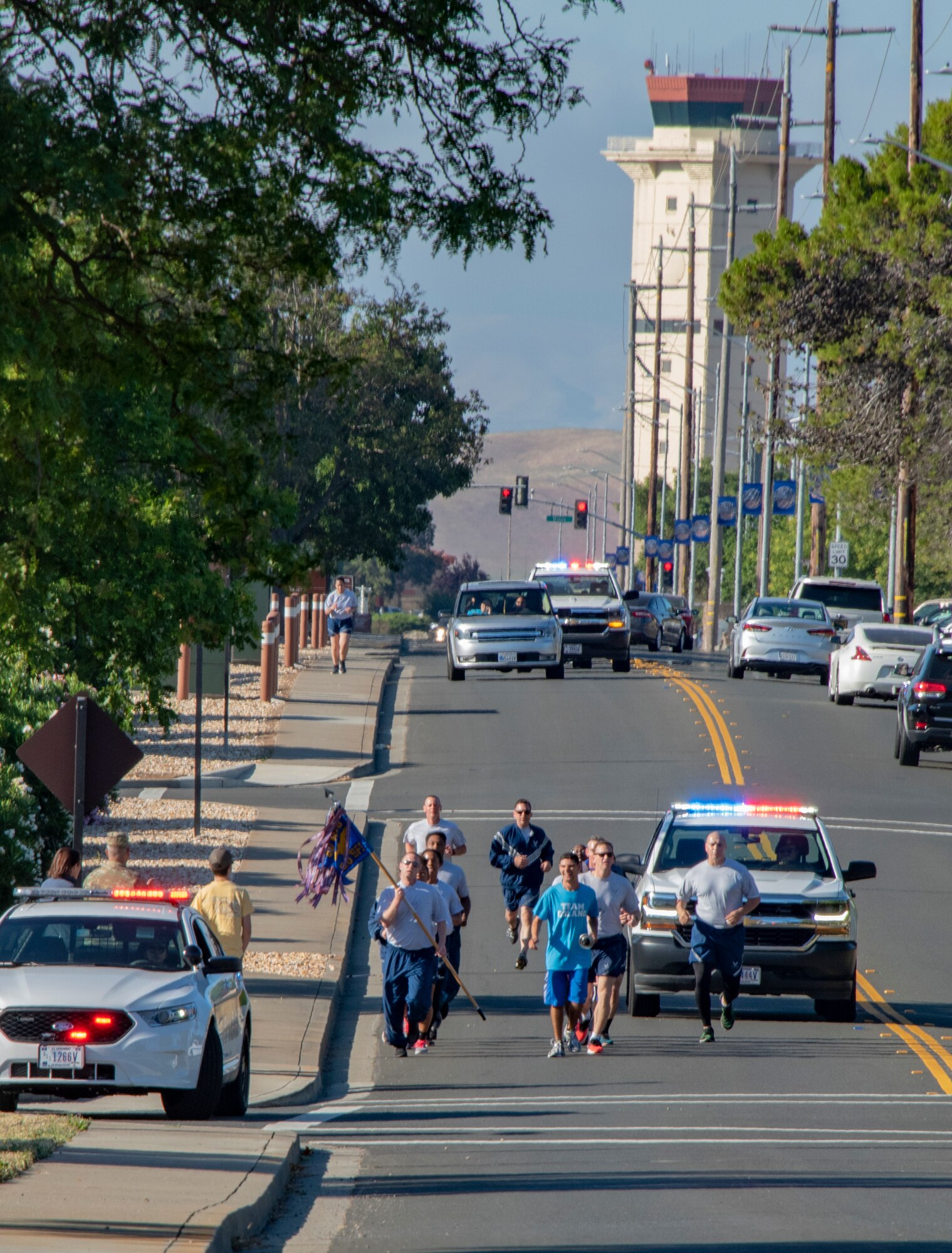 U.S. Air Force 60th Security Forces Squadron defenders and athletes from Solano County make their way northward on Burgan Boulevard during the Northern California Law Enforcement Torch Run June 20, 2019, at Travis Air Force Base, California. Hundreds of Law Enforcement personnel from northern California escorted the Special Olympics torch, the Flame of Hope, throughout their local communities in a relay to the 2019 Special Olympics Northern California Summer Games, being held at the University of California Davis campus June 21-23. (U.S. Air Force photo by Heide Couch)