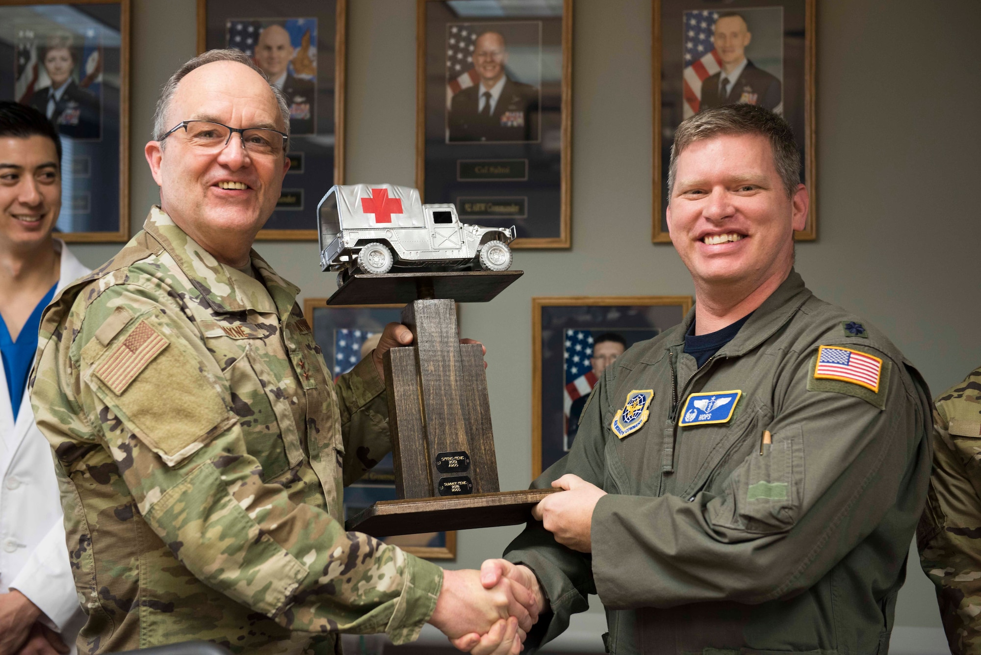 U.S. Air Force Maj. Gen. Lee Payne, Defense Health Agency assistant director, and Lt. Col. Daniel Hatcher, 92nd Aeromedical Squadron flight commander, pose with a commemorative trophy at the Fairchild Air Force Base clinic, Washington, April 26, 2019. Payne visited the medical group to check in on Airmen's progress in developing solutions to the continuous development with the new Medical Health System Genesis program. (U.S. Photo by Senior Airman Ryan Lackey)