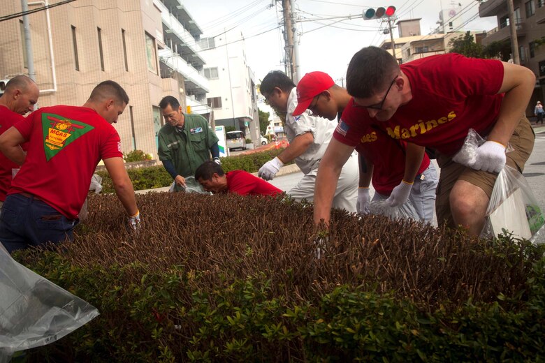 宜野湾市住民と普天間基地の海兵隊員らがボランティアで6月19日、沖縄コンベンションセンター周辺の清掃活動をしました。ボランティアたちは道路沿いにある茂みの中や側溝の中、側溝のふたの下にあるゴミなども拾いました。