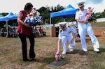 PITI, Guam (June 20, 2019) Debbie Peredo, Seabee Betty’s daughter, Capt. Dale Turner, commanding officer of Naval Facilities Engineering Command (NAVFAC) Marianas, and Lt. Michael Rovinsky, officer in charge of Naval Mobile Construction Battalion 133, place flowers on Seabee Betty’s grave during the Seabee Betty Day memorial celebration. Seabee Betty died June 9, 2003 and was interred June 20, 2003. In 2004, the governor of Guam declared June 20 to be Seabee Betty Day to honor the more than 50 years of dedicated service to the Seabee community on Guam.