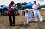 PITI, Guam (June 20, 2019) Debbie Peredo, Seabee Betty’s daughter, Capt. Dale Turner, commanding officer of Naval Facilities Engineering Command (NAVFAC) Marianas, and Lt. Michael Rovinsky, officer in charge of Naval Mobile Construction Battalion 133, place flowers on Seabee Betty’s grave during the Seabee Betty Day memorial celebration. Seabee Betty died June 9, 2003 and was interred June 20, 2003. In 2004, the governor of Guam declared June 20 to be Seabee Betty Day to honor the more than 50 years of dedicated service to the Seabee community on Guam.