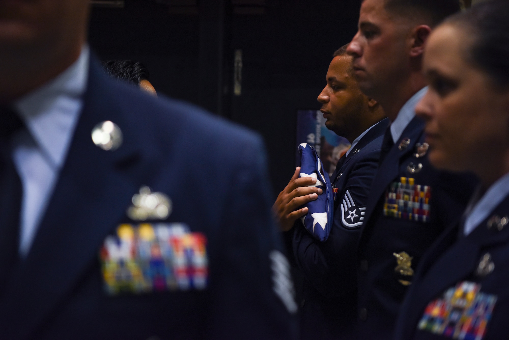 A flag is presented to Military Working Dog Ooyvey’s last handler, Staff Sgt. Dominic Williams, 8th Security Forces Squadron MWD handler, during a memorial service June 19, 2019, at Kunsan Air Base, Republic of Korea. MWD Ooyvey was honored with a moment of silence, the playing of Taps and the reading of the famous poem, “Guardians of the Night.” (U.S. Air Force photo by Staff Sgt. Mackenzie Mendez)