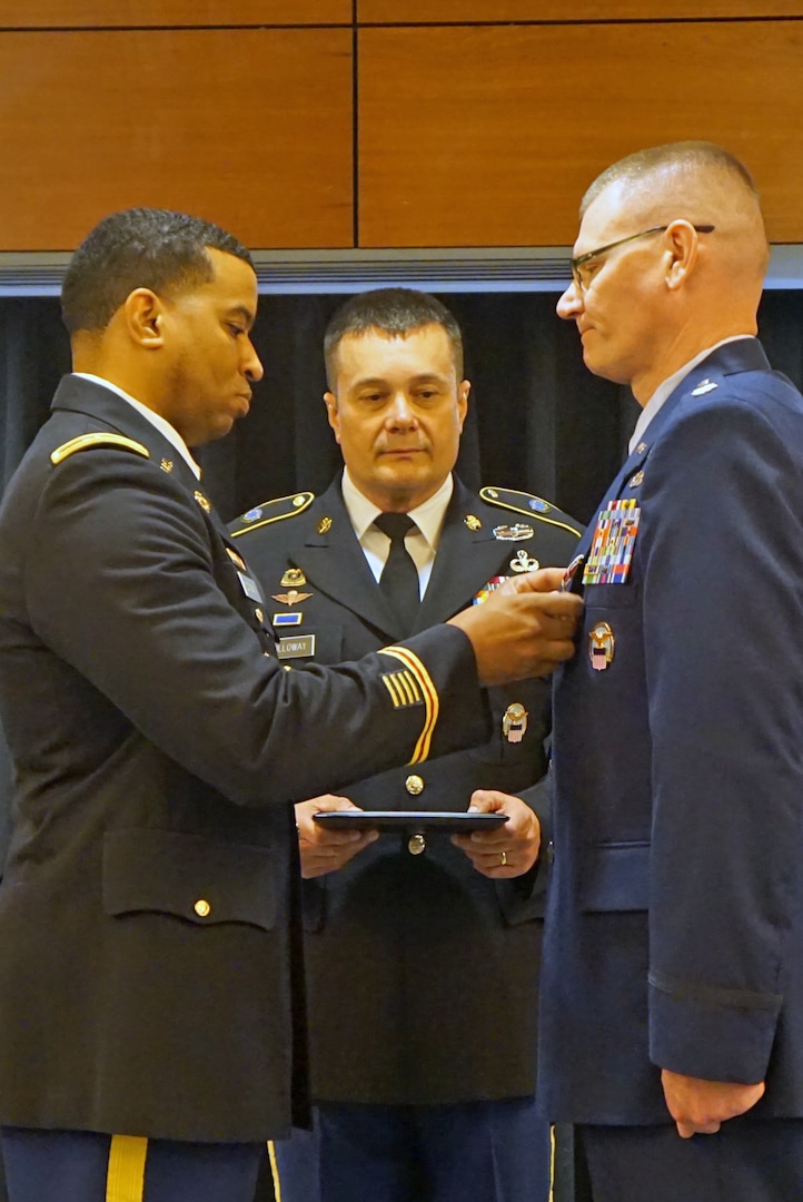 DLA Energy Americas Commander Army Col. Kevin Cotman (left) presented Air Force Lt. Col. Frederick Mueller (right) the Defense Meritorious Service Medal