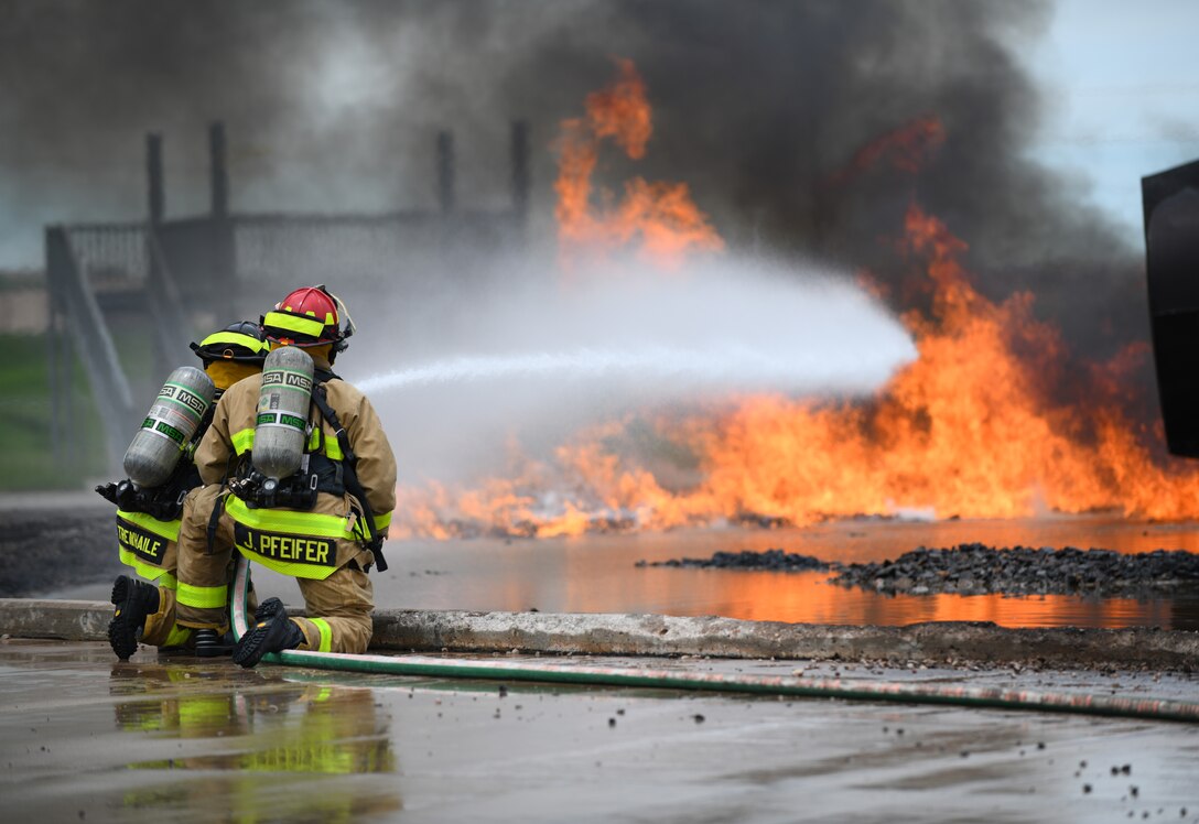 Firefighters from Nebraska’s Army National Guard extinguish a live fuel fire at the training facility on Ellsworth Air Force Base, S.D., June 13, 2019. Firefighters are required to receive aircraft fire training annually. Civilian branches must also complete the training, if they have an active airport within their jurisdiction. (U.S. Air Force photo by Airman 1st Class Christina Bennett)