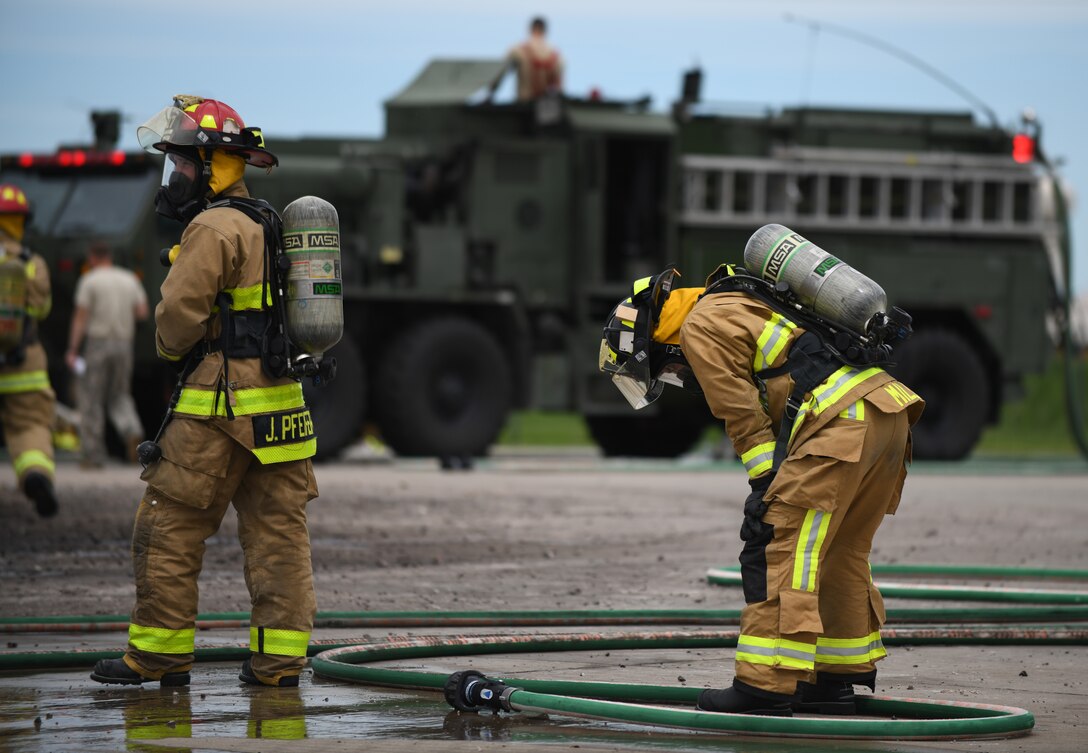 A firefighter from Nebraska’s Army National Guard takes a breather after extinguishing a mock aircraft fire during a qualification training exercise at Ellsworth Air Force Base, S.D., June 20, 2019. Ellsworth AFB is home to one of the last few jet-fueled fire pits in the country. Generally fire pits use propane, rather than jet fuel. Jet fuel fires provide firemen with a more realistic training experience. (U.S. Air Force photo by Airman 1st Class Christina Bennett)