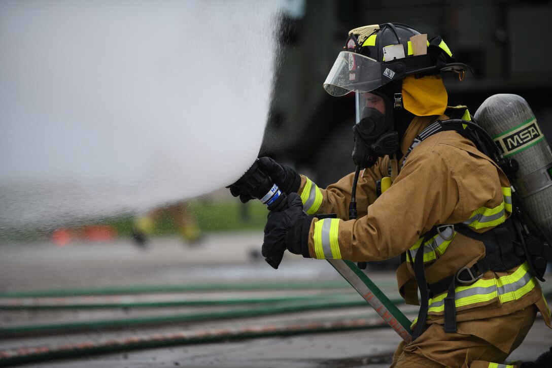 A firefighter from Nebraska’s Army National Guard performs a nozzle stream check, prior to participating in a handline fire training exercise at the fire pit on Ellsworth Air Force Base, S.D., June 13, 2019. Before training, firefighters must examine all of their equipment to ensure that everything works properly and to reduce the chance of safety incidents. (U.S. Air Force photos by Airman 1st Class Christina Bennett)