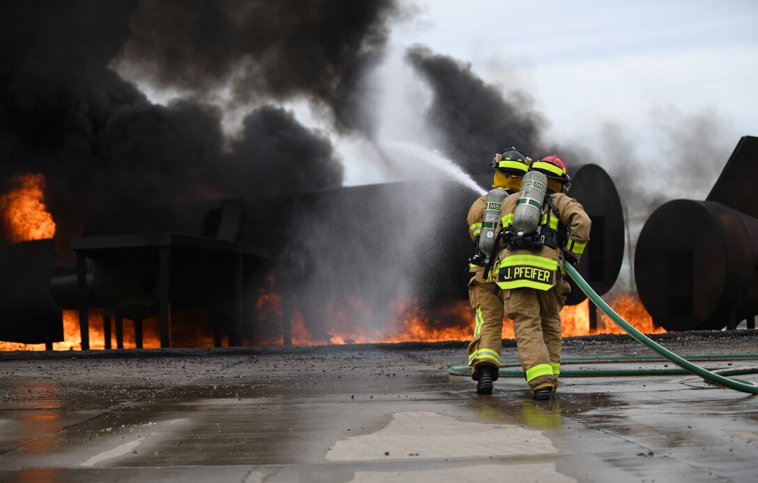 Firefighters from Nebraska’s Army National Guard extinguish a handline fire at the training facility on Ellsworth Air Force Base, S.D., June 13, 2019. A handline fire uses approximately 150 to 200 gallons of jet fuel to enflame the mock aircraft. (U.S. Air Force photo by Airman 1st Class Christina Bennett)