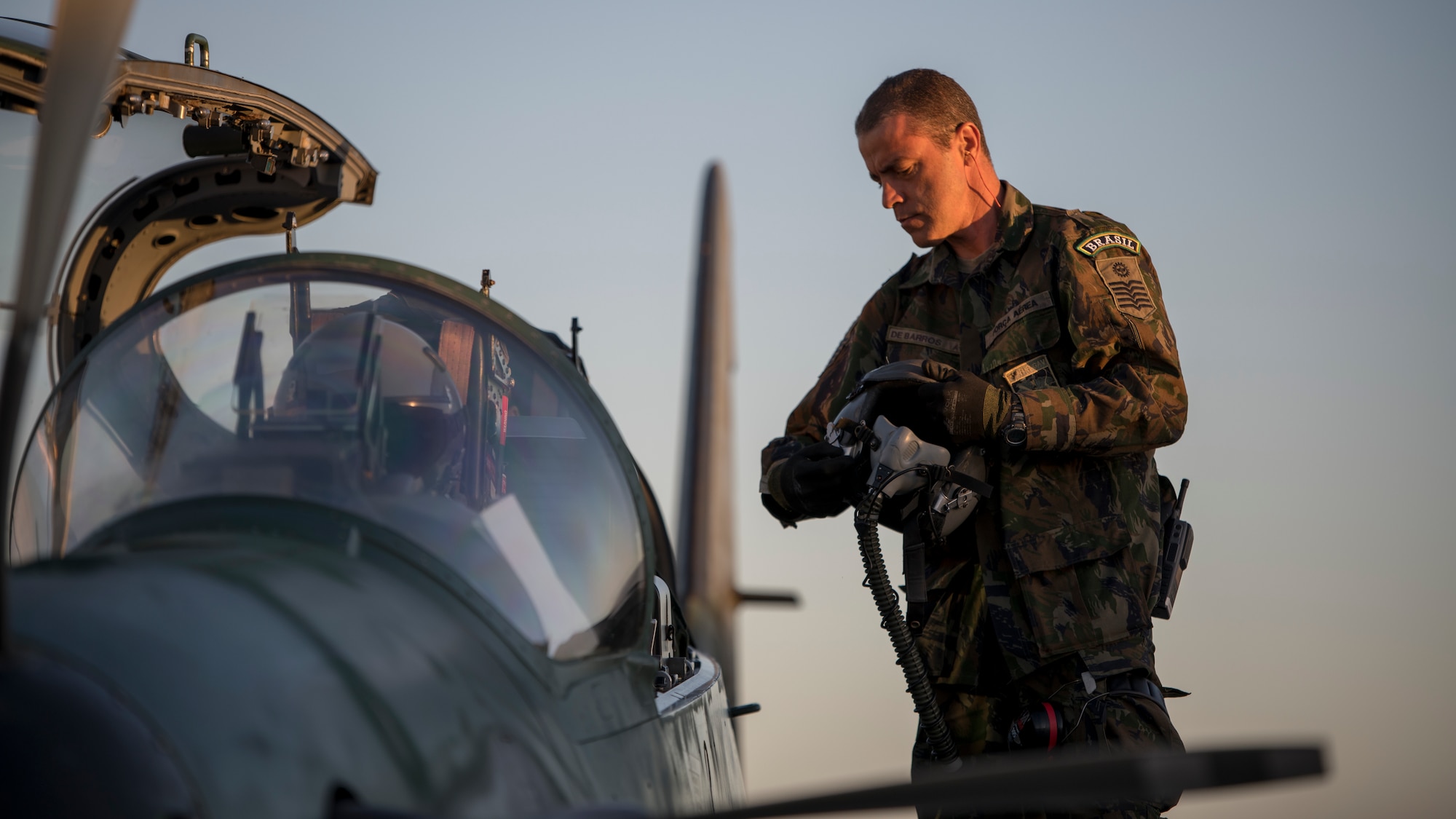 1st Sgt. DeBarros, a crew chief with the Brazilian Air Force, helps a pilot prepare to fly during Green Flag-West 19-8 at Nellis Air Force Base, Las Vegas, Nevada, June 8, 2019. The Brazilians are flying the A-29 Super Tucano in support of the 116th Cavalry Brigade Combat Team’s National Training Center rotation at Fort Irwin, California. (U.S. Air National Guard photo by Master Sgt. Joshua C. Allmaras)