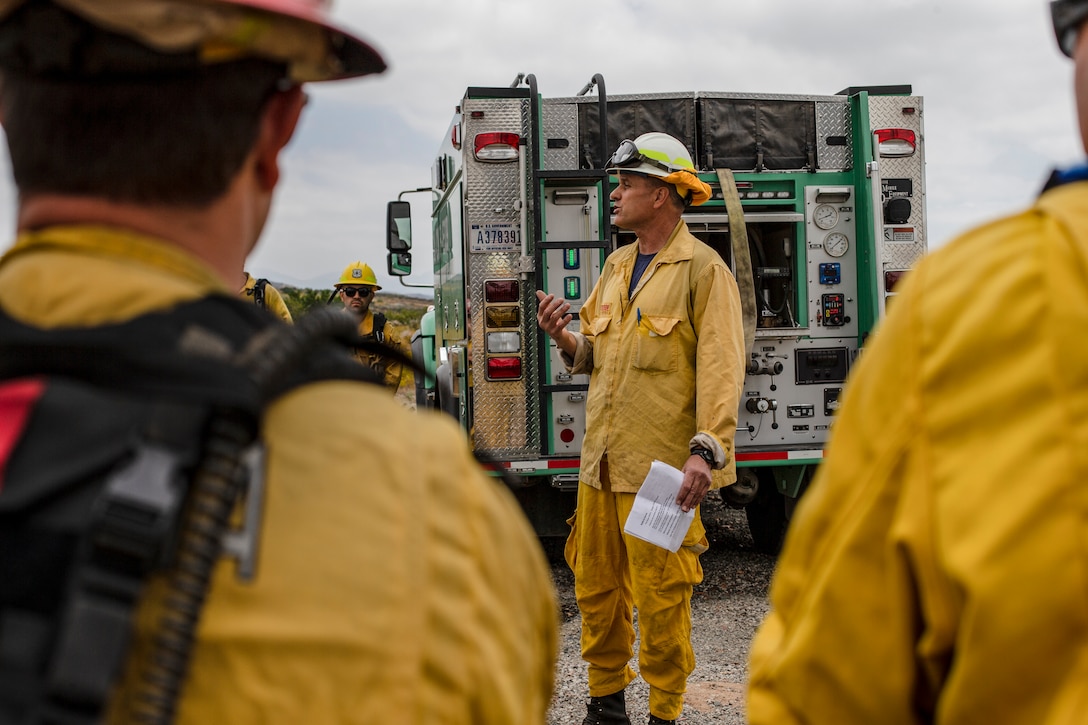 A firefighter gives a brief about the controlled burn at Marine Corps Air Station Miramar, Calif., June 20. MCAS Miramar and local San Diego fire departments conducted this burn to reduce the risk of wild fires around MCAS Miramar and its community by working together on a controlled burn. (U.S. Marine Corps by Lance Cpl. Cheng Chang)