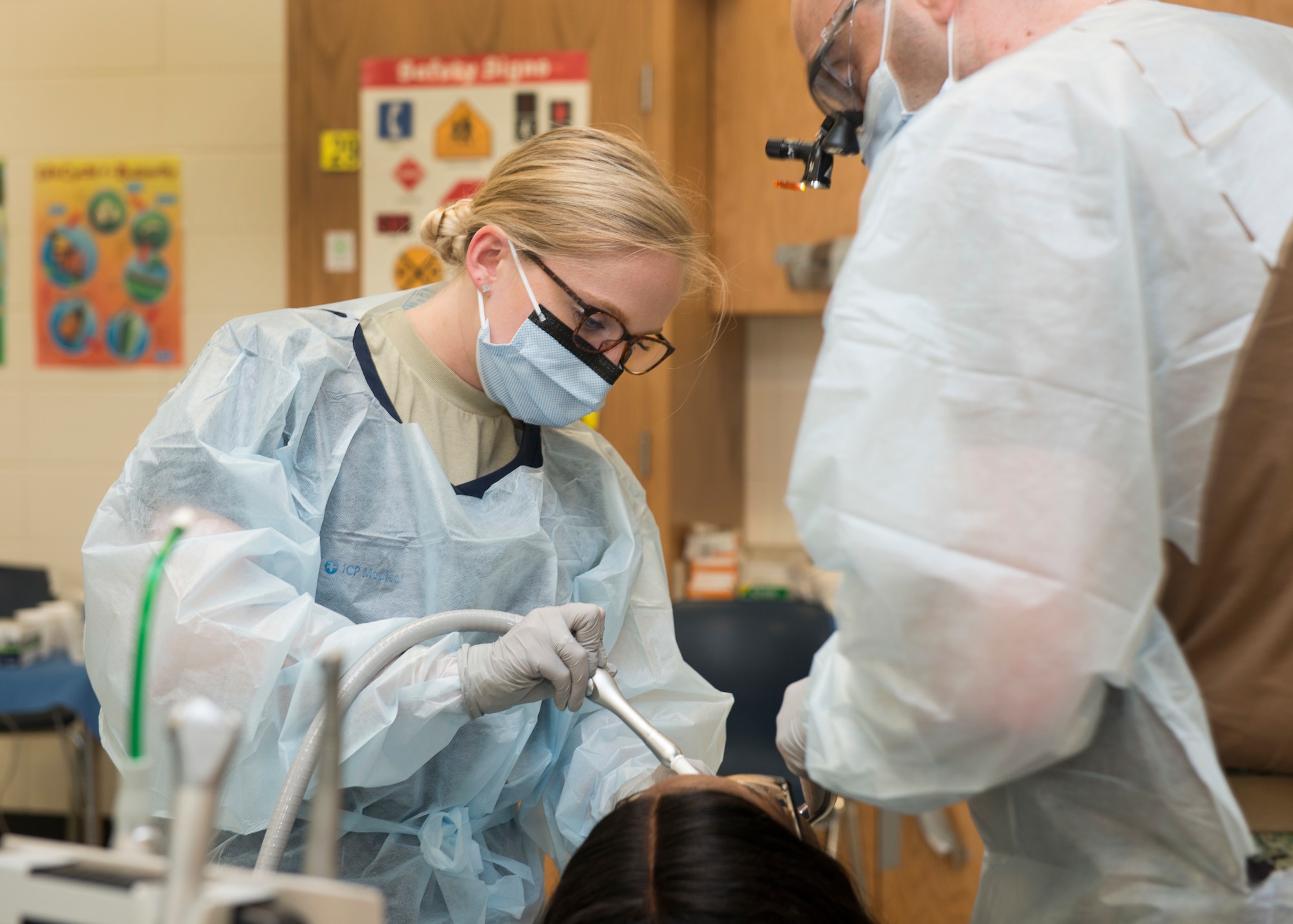 Senior Airman Haley McLane, 103rd Medical Group dental technician, assists a U.S. Navy Reserve dentist during a procedure at Louisville Academy, Louisville, Ga. during East Central Georgia Innovative Readiness Training June 19, 2019. East Central Georgia IRT is a civilian-military collaboration intended to build on mutually beneficial parnterships between U.S. communities and the Department of Defense to meet the training and readiness requirements for Active, Guard, and Reserve Service Members and units while addressing community health needs. (U.S. Air National Guard Photo by Staff Sgt. Steven Tucker)