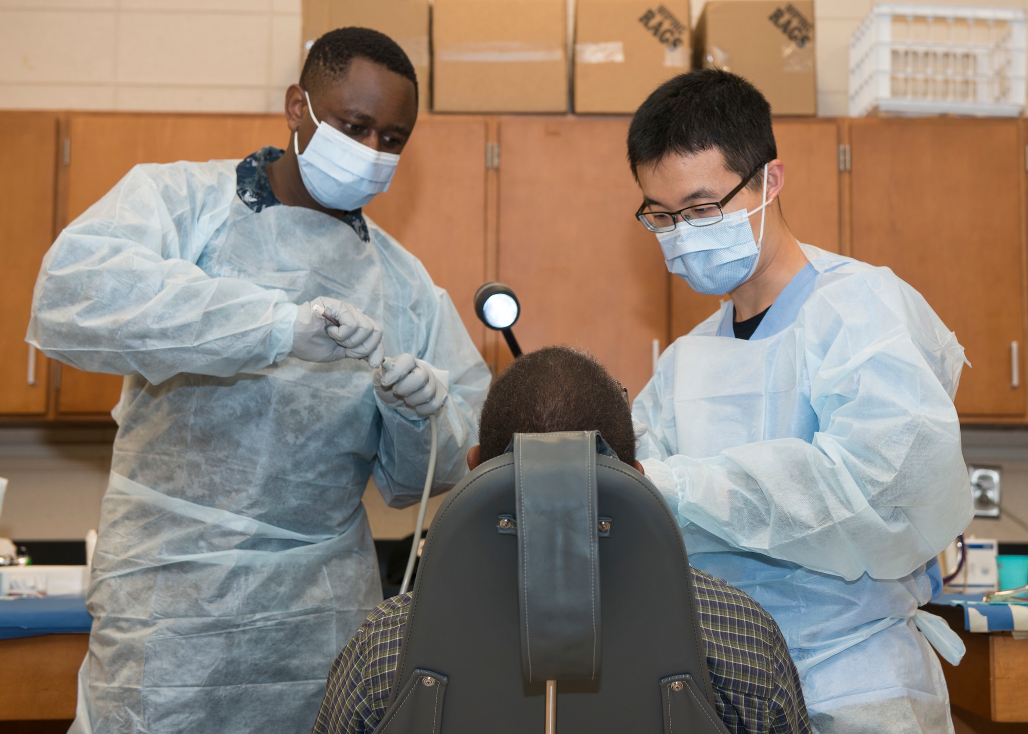 Capt. Xiang Wang (right), 103rd Medical Group dentist, examines a patient during East Central Georgia Innovative Readiness Training at Burke County High School, Waynesboro, Ga. June 20, 2019. East Central Georgia IRT is a civilian-military collaboration intended to build on mutually beneficial parnterships between U.S. communities and the Department of Defense to meet the training and readiness requirements for Active, Guard, and Reserve Service Members and units while addressing community health needs. (U.S. Air National Guard Photo by Staff Sgt. Steven Tucker)