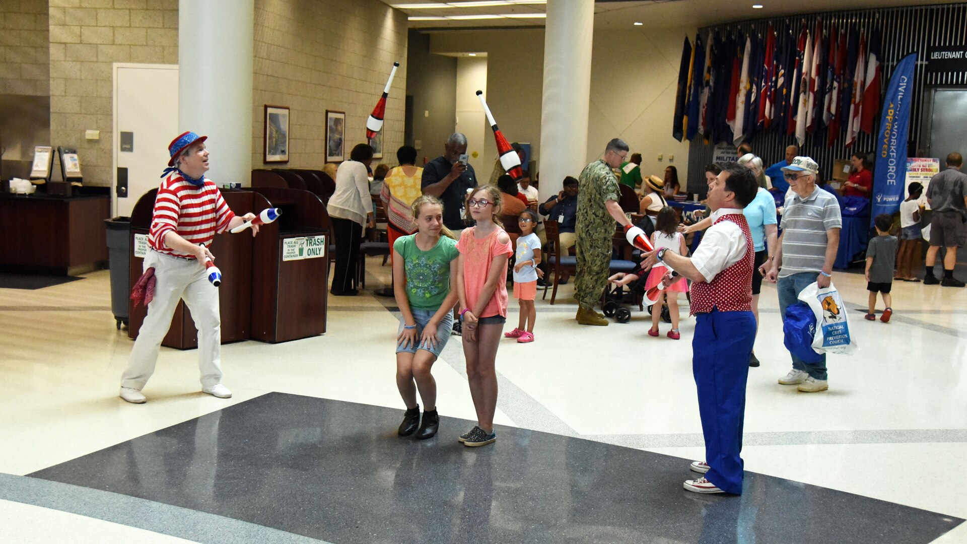 Two men juggling over the heads of two young girls during HQC Family Day.